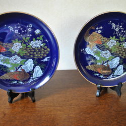 2 wandbordjes (blauw met gouden rand; afbeelding "pauwen")