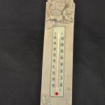 Thermometer op ondergrond met opgelegd houtsnijwerk