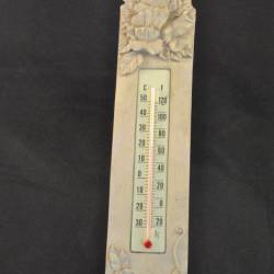 Thermometer op ondergrond met opgelegd houtsnijwerk